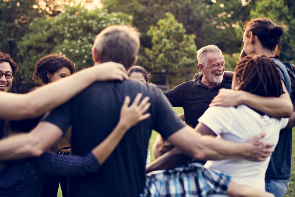 Group of people support unity arm around together